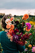 Woman with lush bouquet of flowers in the garden