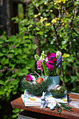 Easter decorations made of spring flowers with anemones and hyacinths, Easter nests and an outdoor Easter bunny