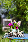 Spring table decoration with hyacinths, wreath of pussy willows and olive branches on a blue table in the garden