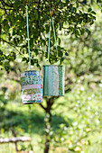 Homemade lanterns with a patchwork look made from colourful fabric scraps hanging in the garden