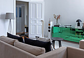 Sofa with black cushions, mirrored sideboard and floor lamp in a modern living room