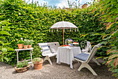 Inviting seating area in the garden with white parasol and potted plants