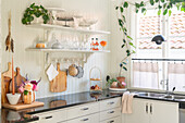 Bright kitchen with open shelving and indoor plants