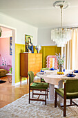 Retro-look dining room with mustard yellow wall accents and chandelier