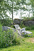 Deckchair next to wild meadow flowers in the summer garden