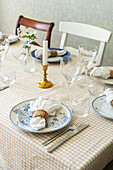 Set dining table with chequered tablecloth and candlestick