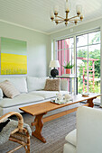 Bright living room in Scandinavian design with rattan armchair and retro lamp