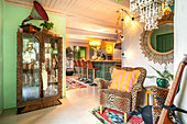 Eclectic interior design with leo-look armchairs and antique display cabinet