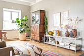 Rustic wooden cupboard and modern shelf with ceramic vases in the living room