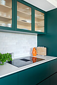 Modern kitchen with blue-green fronts and ceramic tiled splashback