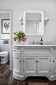 Bathroom with grey washbasin and marble washbasin top, bouquet of tulips