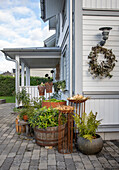 Plant arrangement and wreath decoration in front of a white wooden house