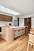 Modern kitchen with wooden details and kitchen island with bar stools