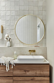 Modern bathroom with round mirror and wooden washbasin