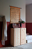 Wooden cupboard and school map on red and white wall in corridor
