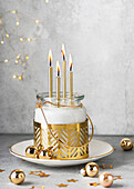 Advent wreath in a glass with golden candles and Christmas baubles