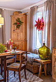 Dining room with rustic wooden furniture, Christmas decorations and large glass vase