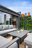 Modern roof terrace with grey lounge furniture and vertical planting