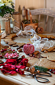 Table with craft materials for Christmas decorations, gingerbread, ribbons and pine cones