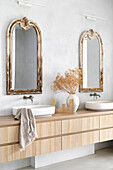 Double washbasin with antique mirrors and dried flower arrangement