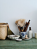 Natural cleaning utensils and ceramic pots on a wooden shelf