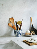 Kitchen utensils in a blue and white porcelain mug on a marble worktop