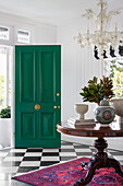 Bright entrance area with green front door and chequered marble floor