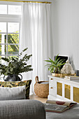 Bright living room with plants and white curtains