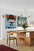 Dining room with solid wooden table and artwork on the wall