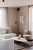 Bright living room with modern cream-coloured furniture and abstract art
