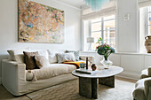 Living room with cosy sofa, abstract painting and green marble table