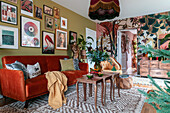 Living room with orange velvet sofa, colourful walls and colourful wall art