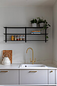 Modern kitchen with golden tap and open shelves