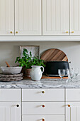 Kitchenette with marble counter, ceramic crockery, toaster and basil pot