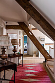 Hallway with rustic wooden beams and red carpet runner
