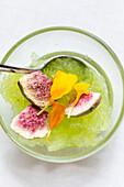 Green granita dessert with freeze-dried figs and edible flowers