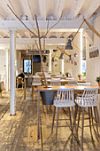 Bright café with wooden beams and potted plants integrated into the table