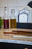 Rhubarb stalks and bottles of oil and vinegar on a marbled kitchen worktop