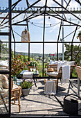 Cosy conservatory with rattan armchairs and views of the countryside