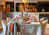 Festively laid dining table with candlesticks in a cosy eat-in kitchen