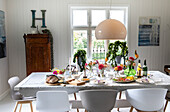 Gedeckter Esstisch im skandinavischen Design mit Blumenschmuck
