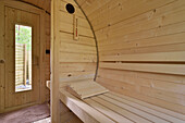 Wooden sauna with benches and glass door in a holiday home