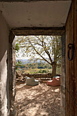 View from historic building onto terrace with cosy cushions and landscape