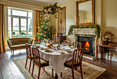 Weihnachtlich dekoriertes Esszimmer im viktorianischen Stil mit Kamin und Tannenbaum