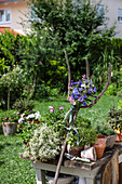 Gardening table with flower fork and summer flowers in the garden