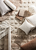 Various cushions, rugs and fabrics in natural colours