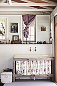 Rustic washbasin with floral curtain panelling in a creative studio