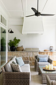 Überdachte Terrasse mit Rattanmöbeln, Deckenventilator und Gasgrill