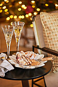 Weihnachtliche Desserts und Champagnergläser auf rundem Beistelltisch