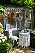 Romantic garden seating area with crocheted blanket and wooden chair